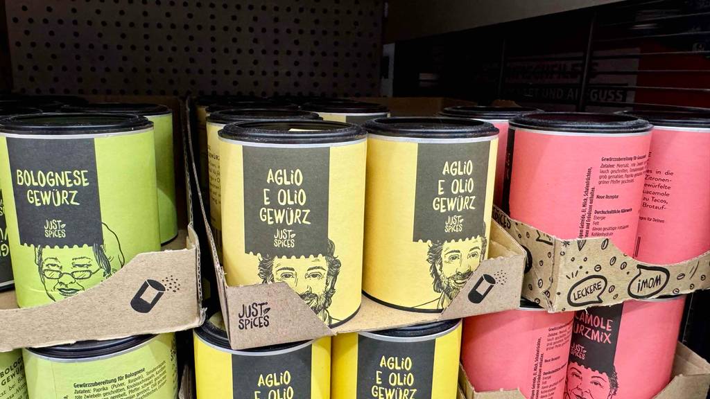 Just-Spices im Test: Mehrere Dosen unterschiedlicher Sorten stehen gestapelt in einem Regal.