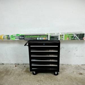 Die verpackte Juwel Novaplus 600 Lift liegt auf einem schwarzen Rollcontainer in einem Kellerraum.