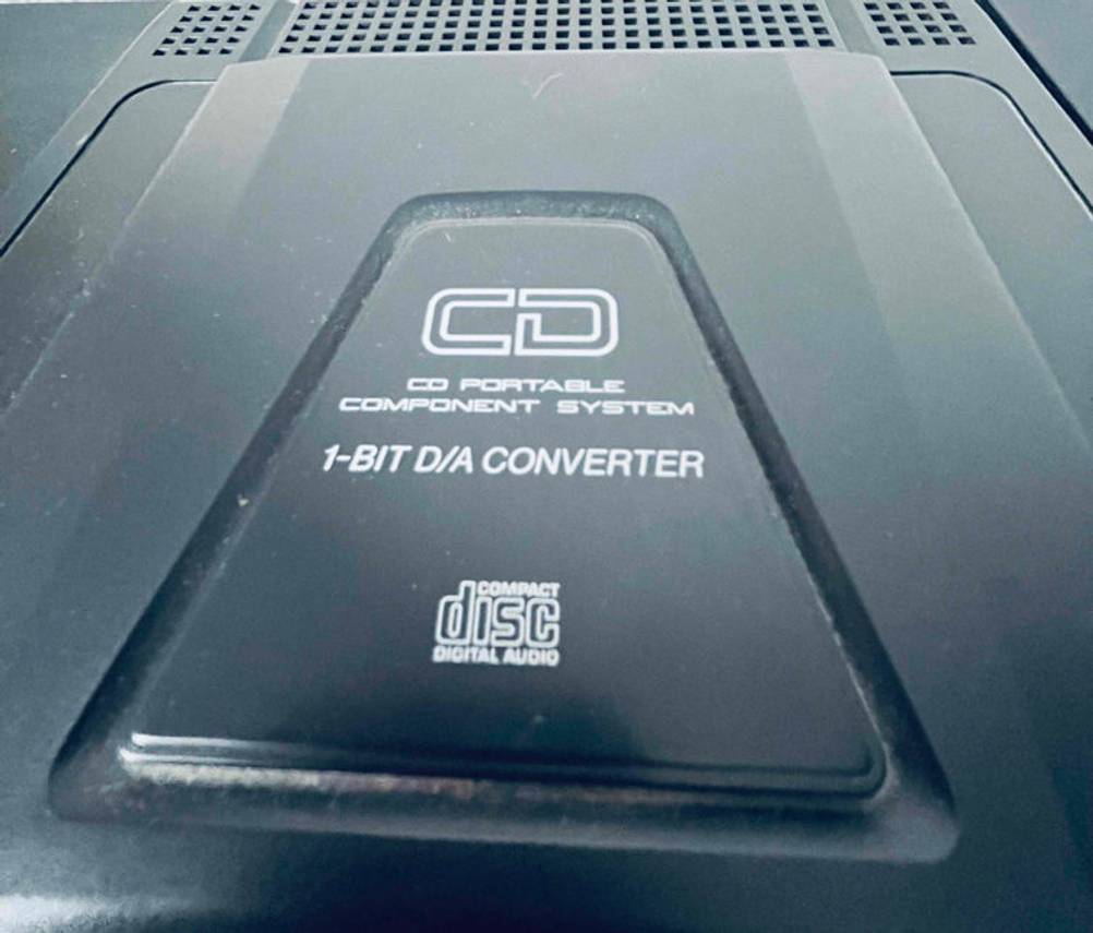 Detailaufnahme des CD-Decks mit dahinter liegenden Lüftungsöffnungen einer getesteten Stereoanlage.