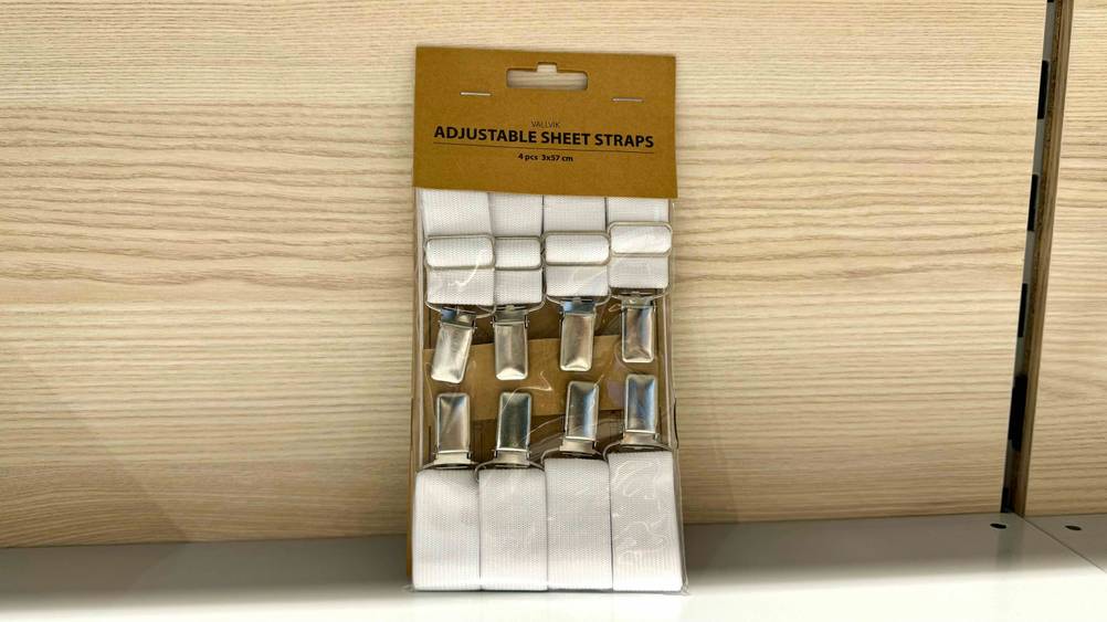 Bettlakenspanner-Test: Ein Set mit acht Stück steht verpackt vor einer Holzwand.