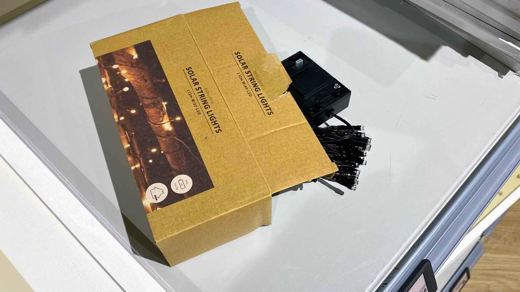 Solar-Lichterketten für Außen im Test: eine schwarze Lichterkette befindet sich in einem geöffneten hellbraunen Verpackungskarton.