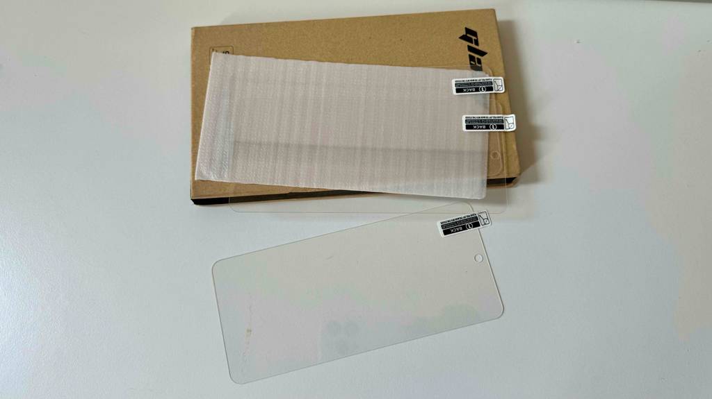 Samsung Galaxy A51-Panzerglas im Test: Auf einer weißen Fläche liegt ein Set mit 3 Folien.