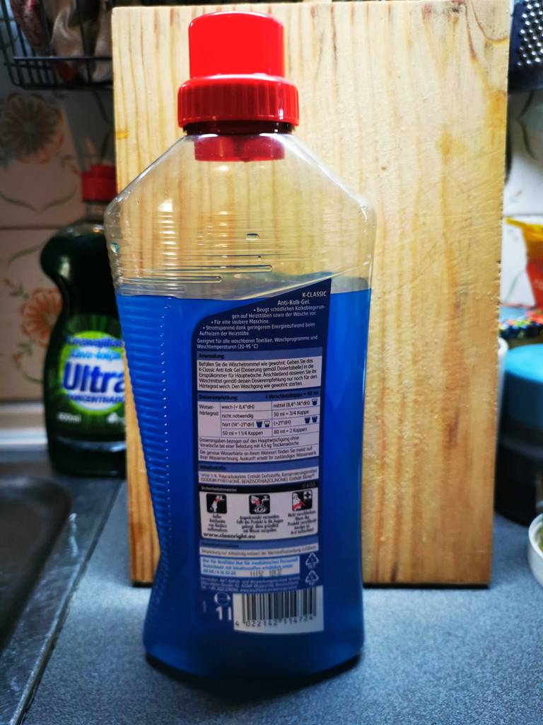 Eine Flasche getesteter Waschmaschinen-Entkalker steht mit der Rückseite nach vorn auf einer Küchenarbeitsplatte.