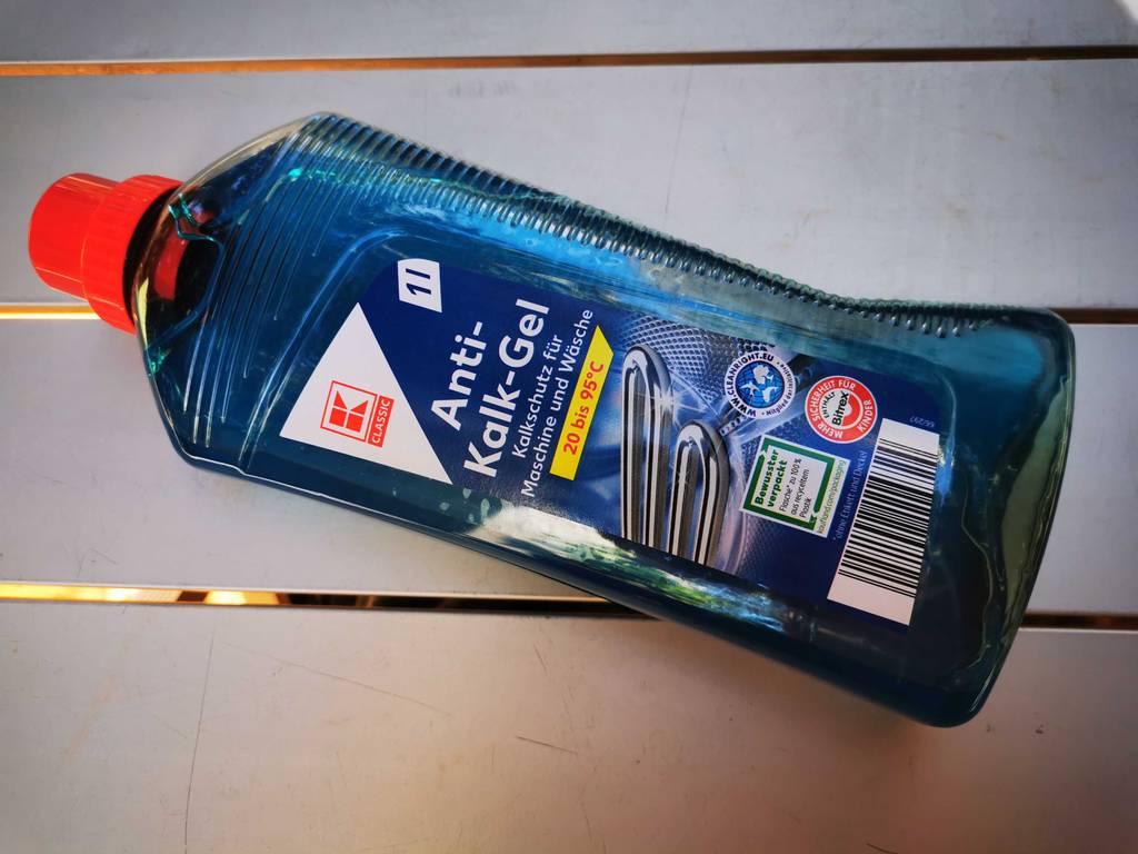 Eine Flasche Waschmaschinen-Entkalker liegt zum testen auf einem Tisch.