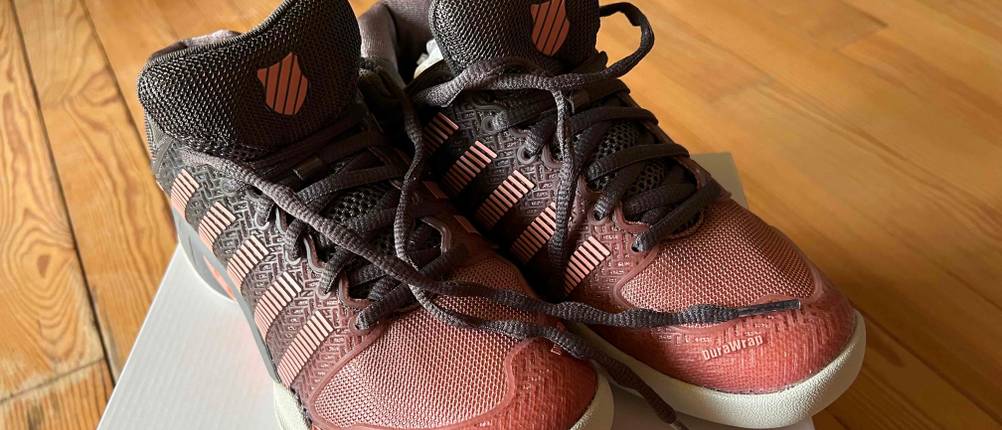Tennisschuhe in Schwarz-Rot auf dem Karton stehend.