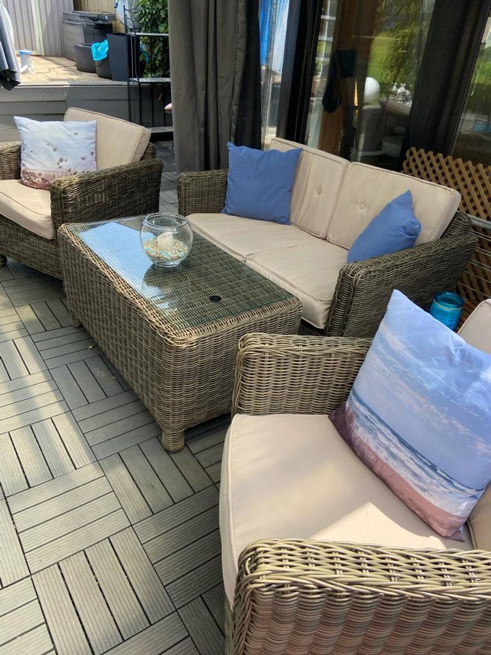 Rattan-Gartenmöbel-Test: Ansicht einer mit Kissen bestückten Sitzgruppe, inklusive Sessel, Sofa und Tisch.