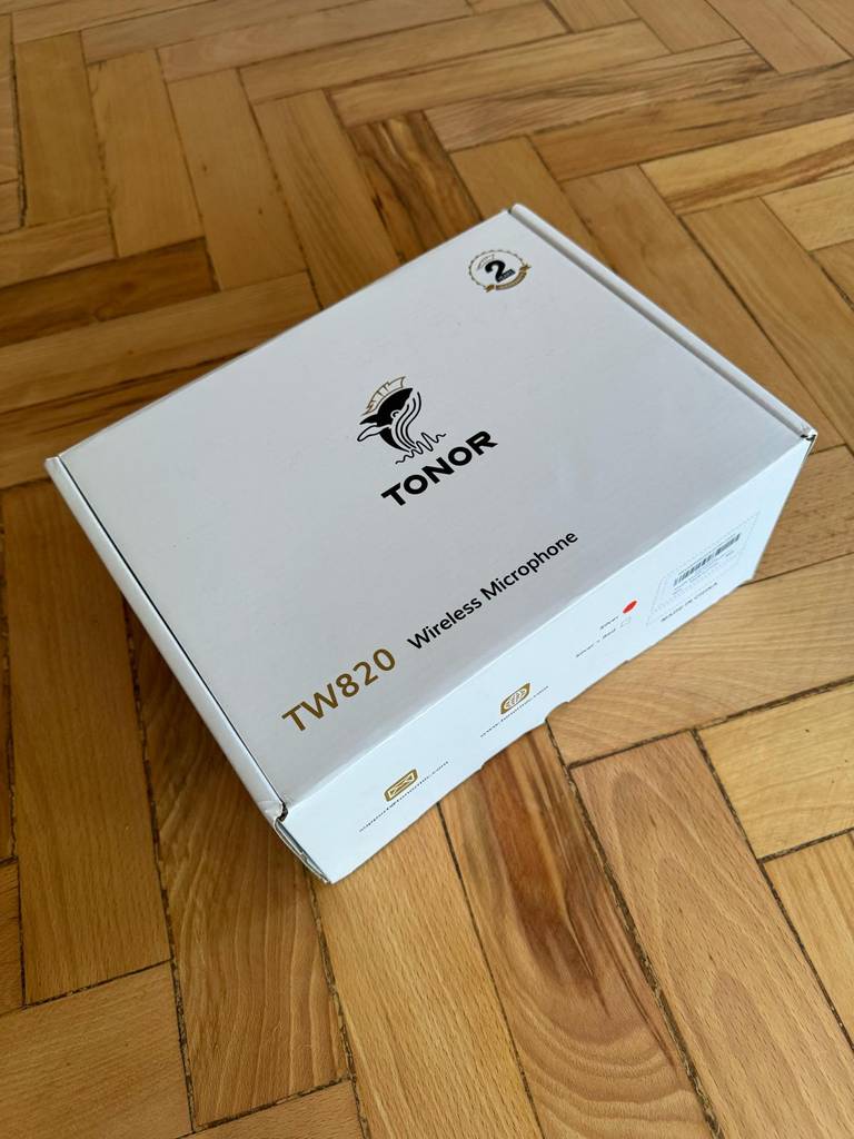 Ansicht der weißen, auf Holz liegenden Verpackung eines Funkmikrofons im Test.