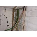 Verschiedene Kabel kommen aus der Decke und den Wänden.