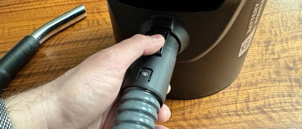 Eine Hand befestigt den Schlauch am Kärcher 1.348-300.0