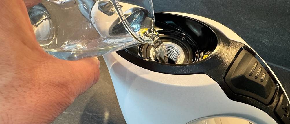 Eine Hand schüttet Wasser in den Kärcher ‎1.516-400.0