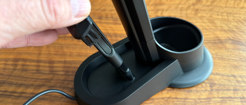 Eine Hand nimmt einen Aufsatz vom Kärcher CVH 3 Plus aus der Ladestation