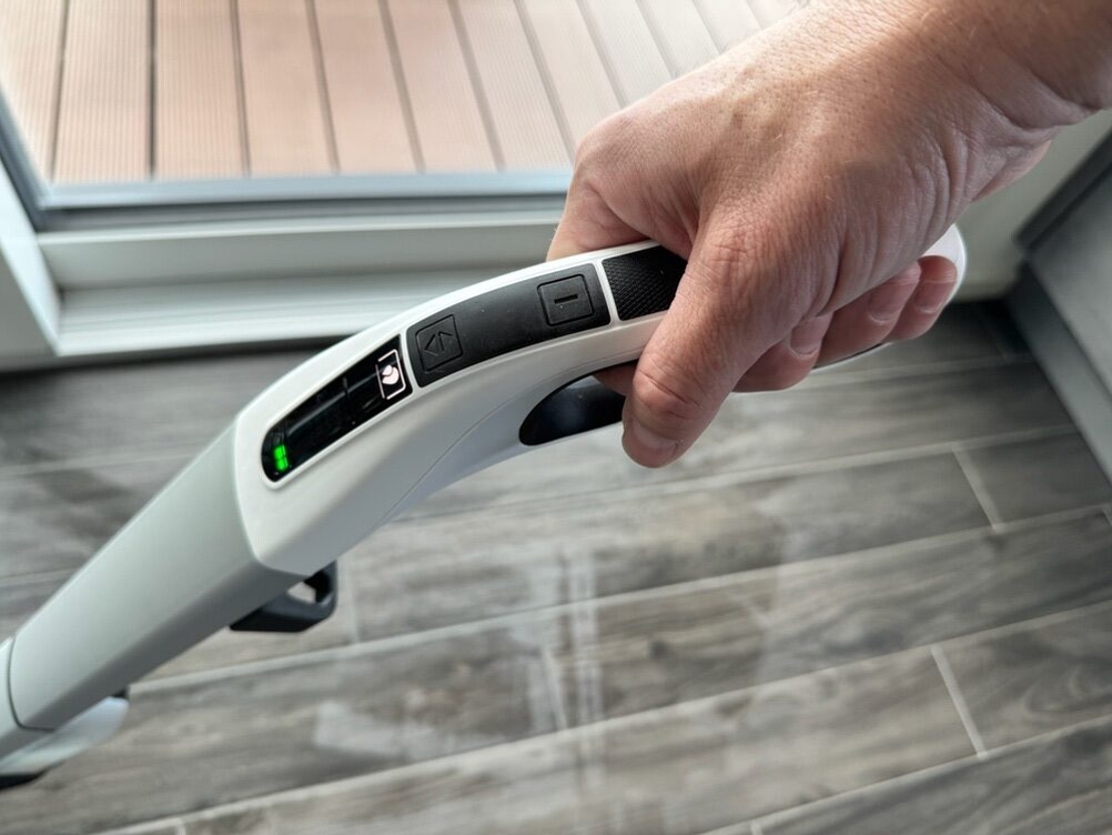 Eine Hand hält den Kärcher FC 4-4 während dem Saugen fest