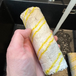 Eine Hand hält eine Rolle des Kärcher FC 4-4 mit leichten Verschmutzungen fest