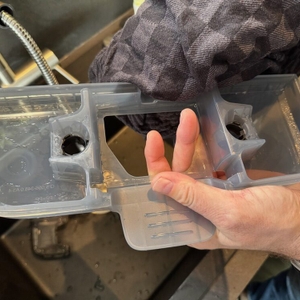 Eine Hand trocknet einen Behälter des Kärcher FC 4-4 ab