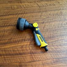 Die Kärcher-Multifunktions-Spritzpistole Plus liegt auf einem Holztisch