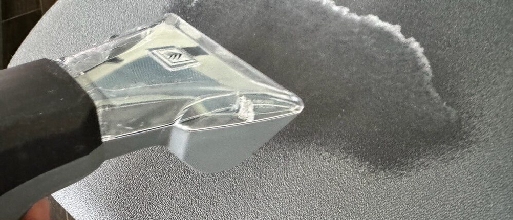 Die Düse des Kärcher Puzzi 8/1 reinigt einen Stoffstuhl