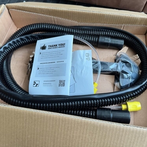 Geöffneter Karton mit Schlauch und Anleitung des Kärcher Puzzi 8/1