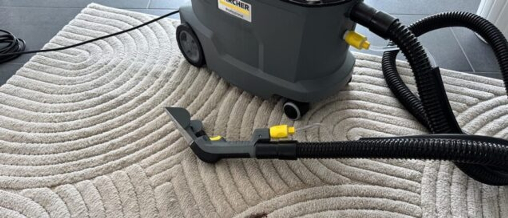 Kaffeefleck auf einem beigen Teppich, Kärcher Puzzi 8/1 im Hintergrund