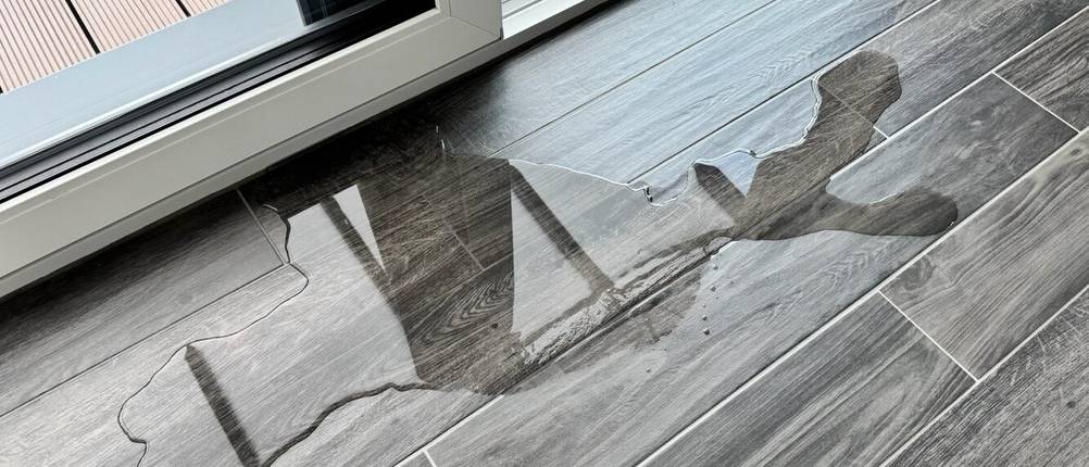 Eine Wasserpfütze auf gefliestem Boden