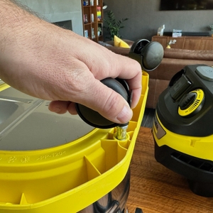 Eine Hand befestigt eine der Rollen des Kärcher WD 6 P Premium