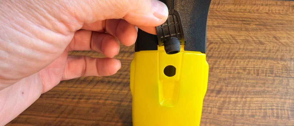 Eine Hand entfernt einen Stopfen vom Behälter des Kärcher WV 2 Black Edition