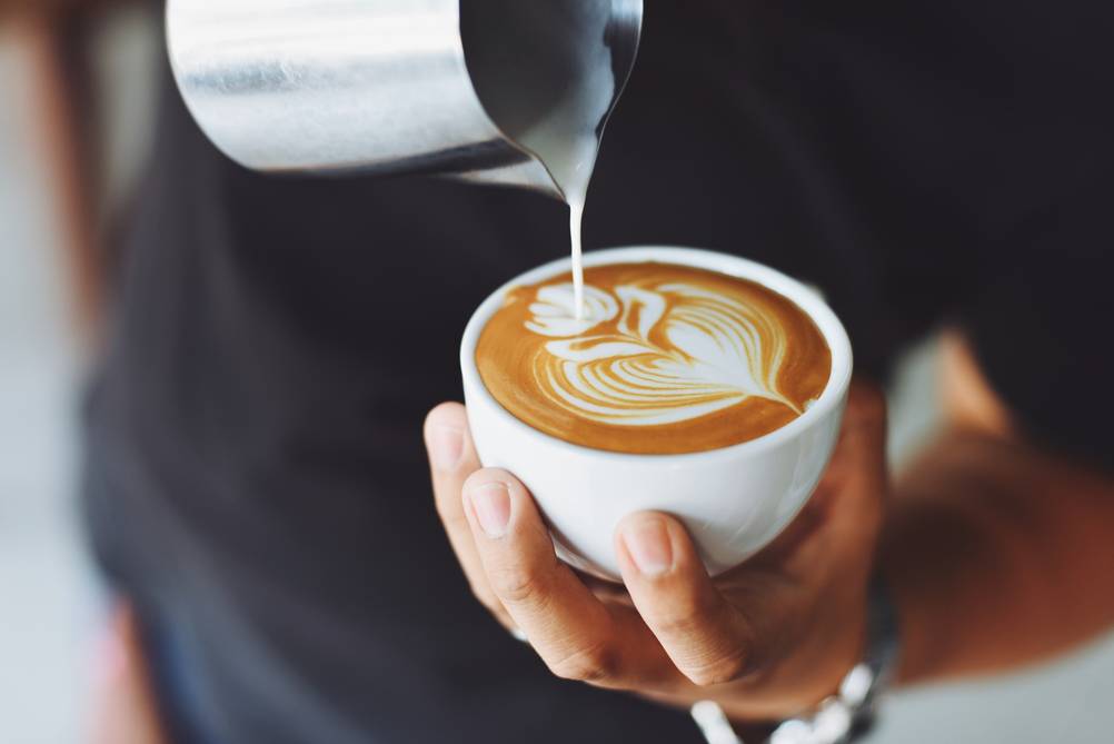 Latte Art wird auf einem Milchkaffee gemacht.