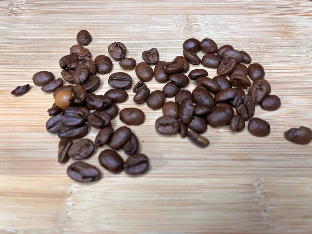 Getestete Kaffeebohnen auf einer Holzfläche.