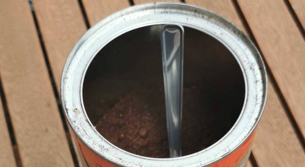 Kaffeedosen-Test: eine runde offene Kaffeedose, befüllt mit Pulverkaffee, in dem ein Löffel steckt, von oben betrachtet.