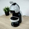 Die Krups Nescafé Dolce Gusto Mini Me KP120H steht in Komplettansicht auf einer Küchenfläche. Die Maschine ist betriebsbereit aufgebaut.