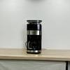 Die Krups KM8328 Kaffeemaschine steht mittig auf einer leeren Arbeitsfläche. Das Gerät ist vollständig aufgebaut und angeschlossen.