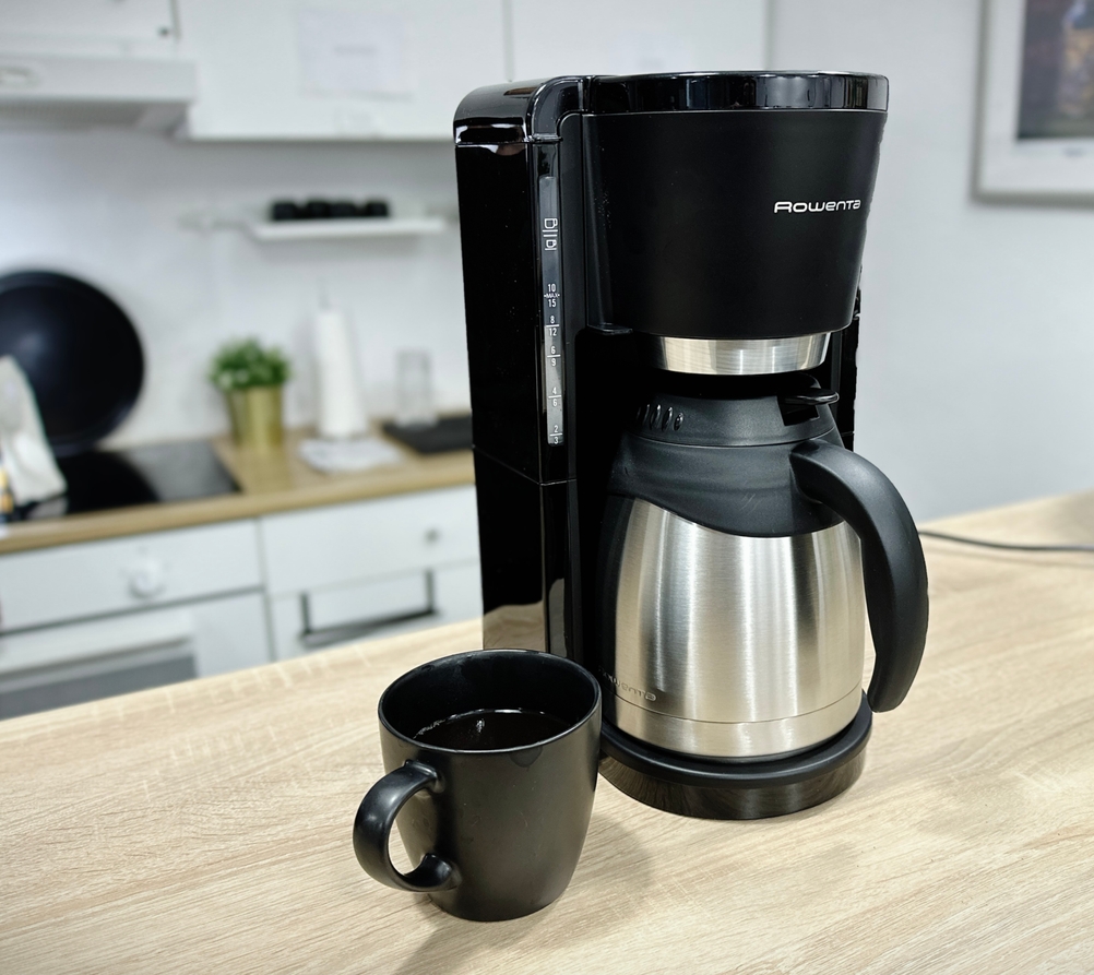 Die Rowenta Milano CT3818 Kaffeemaschine mit Thermoskanne steht allein auf einer Küchenarbeitsplatte. Die Front zeigt Wasserstandsanzeige und Bedienfeld.