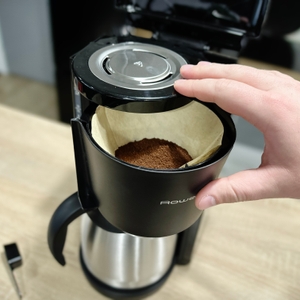 Detailansicht des eingesetzten Kaffeefilters in der Rowenta Milano CT3818 mit frisch eingefülltem Kaffeepulver. Eine Hand hält den Filteraufsatz geöffnet.
