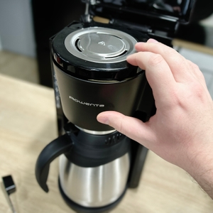Eine Hand schließt den Schwenkfilter der Rowenta Milano CT3818 Kaffeemaschine nach dem Einfüllen des Kaffeepulvers. Der Deckel rastet hörbar ein.