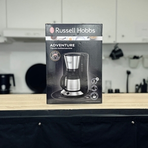 Vorderseite der Verpackung der Russell Hobbs Adventure mit Produktabbildung und Piktogrammen zu Funktionen wie Thermokanne und Aromatechnologie.