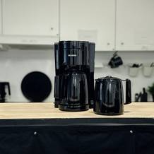 Die Severin KA 9250 mit zwei Thermoskannen steht auf einer Holzarbeitsfläche in einer Küche. Eine schwarze Tasse steht daneben.