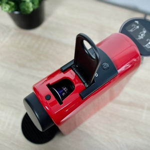 Die Nespresso-Kapsel ist von oben im Gerät sichtbar. Der Einwurfbereich ist geöffnet.