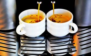 Zwei Kaffeetassen stehen unter einem getesteten Kaffeevollautomaten.