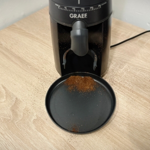 Der Mahlvorgang der Kaffeemühle für Siebträger von Graef ist zuende und einiges an Pulver liegt auf der Auffangschale.
