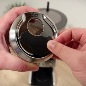 Der Pulverbehälter der Siebträger-Kaffeemühle von Sage ist geöffnet.