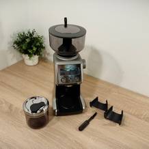 Der Lieferumfang der Kaffeemühle für Siebträger von Sage steht auf einem Tisch.