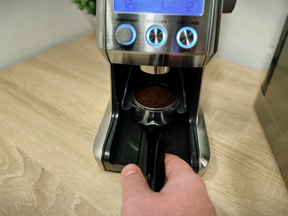 Kaffeepulver wird direkt in einen Siebträger von der Kaffeemühle der Marke Sage gemahlen.