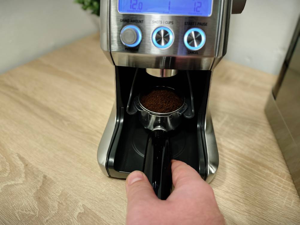 Kaffeepulver wird direkt in einen Siebträger von der Kaffeemühle der Marke Sage gemahlen.