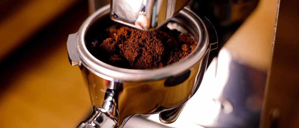 Nahansicht von gemahlenem Kaffee in einem Siebträger.