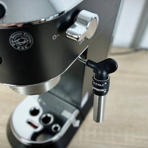 Die De'Longhi Dedica Style EC 685.B steht vollständig aufgebaut auf einer Arbeitsfläche. Die Dampfdüse und der Siebträgerbereich sind deutlich sichtbar.