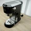 Die De'Longhi Dedica Style EC 685.B ist vollständig aufgebaut und steht auf einem Tisch. Die Maschine ist frontal zu sehen, alle Elemente sichtbar.