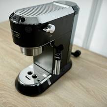 Die De'Longhi Dedica Style EC 685.B ist vollständig aufgebaut und steht auf einem Tisch. Die Maschine ist frontal zu sehen, alle Elemente sichtbar.