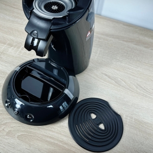 Die Philips Senseo HD6554/68 steht vollständig aufgebaut auf einer Holzfläche. Vorderseite und Bedienelemente sind gut sichtbar.