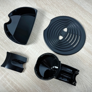 Zum Lieferumfang der Philips Senseo HD6554/68 gehören Padhalter, Anleitung und Tropfschale. Die Einzelteile liegen auf einem Tisch.