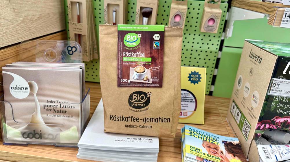 Eine Packung des Kaffeepulver im Test steht in einem Regal mit Kosmetikartikeln.