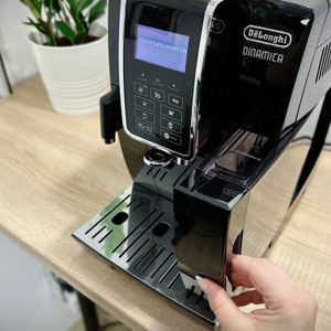 Die Vorderseite der De'Longhi Dinamica (ECAM350.55.B) zeigt das Bedienfeld mit digitalem Display. Die Anzeige fordert zum Einsetzen des Wassertanks auf.